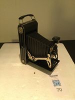 Side angle of the vintage Kodak camera showing foldable bellows and metal handle