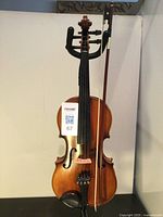 Violin and bow hanging on stand, full front view
