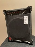 Front view of Yamaha bass amplifier showing speaker grille, control knobs, and robust black corner protectors.