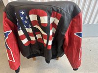 Rear view of leather jacket showing large American flag design in red, white, and blue on back and red sleeves with blue stars and USA text.