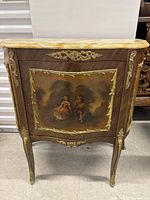Front view showing hand-painted couple on door panel, brass appliques, and marble top.