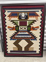Full framed wool tapestry depicting geometric totem pole figure in multicolored wool.