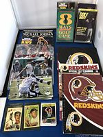 Overview of sports magazines, golf books, trading cards, autographed photo, Redskins yearbook and binder