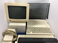 Apple IIc central unit, CRT monitor, external disk drive, power supply and cables arranged together