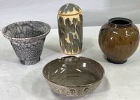 Set of four art pottery pieces by Richard Trost shown together: bowl with notches, flared crackle glaze vase, brown high gloss vase, covered jar with paint dabs and lid