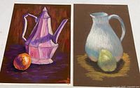Two pastel still life paintings by Richard Trost shown side by side on a white surface. One painting features a pink and purple teapot with an orange fruit, the other a white pitcher with a green pear.