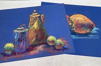 Photo of two original pastel paintings depicting still life scenes with brass teapot, tin container, apples, and a lemon on blue backgrounds.