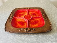 Angled view showing vibrant orange divided sections and textured matte brown frame with embossed fruit design.