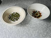 Two 1970s serving bowls side by side on white textured surface showing their floral designs and sizes.