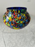 Front angled view showing colorful teardrop patterns and shiny blue interior.