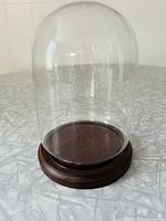 Glass cloche dome resting on dark wood base, showcasing the entire unit assembled