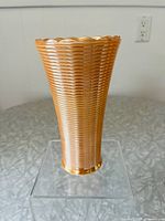 Front view of tall narrow Peach Lustre vase showing its horizontal ribbed texture and scalloped rim.