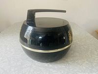 Black curling rock shaped ice bucket showing front angle with handle and gold strip