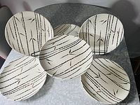 Six vintage Ironstone plates with a black bamboo pattern arranged on the table shows overall set condition and design.