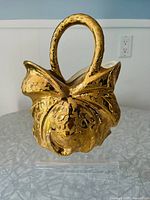 Front view of the mid-century 24K gold over porcelain weeping gold basket showcasing decorative bow and handle detail.