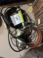 Photo of vintage handheld microphone alongside over-ear headphones with cables coiled, showing connectors and wear.