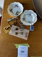 Overview of two porcelain plates and assortment of jewelry on table