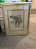 Framed print showing a polar bear in a realistic black and white style, signed and numbered by the artist, with gold frame and cream mat.