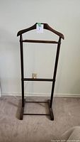 Front view of the wooden valet stand showing the missing top portion and rectangular base.