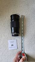 Top down photo of Vivitar telephoto lens next to measuring tape showing length approximately 16cm.