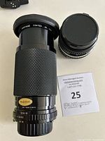 Macro zoom lens showing textured grip and aperture/focus markings, made in Japan.