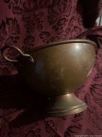 Side view of copper plated bowl showing handle and pedestal base