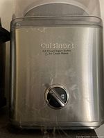 Front view of the stainless steel Cuisinart ice cream maker showing the brand, model name, and control dial.