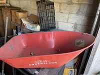 Red metal Erie Contractor wheelbarrow bucket showing side with logo and condition.