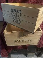 Photo of two wooden wine boxes stacked, showing the printed text labels and natural wood texture.