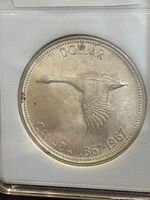 Obverse of 1967 Canadian silver dollar showing flying goose design and inscriptions.