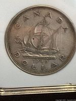 Reverse side of the 1949 Canadian silver dollar showing the detailed sailing ship labeled 'NEWFOUNDLAND' with the date 1949 and surrounding wording 'CANADA DOLLAR'.
