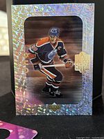 Front holographic card image of Wayne Gretzky in Edmonton Oilers uniform with 'The Great One' branding.