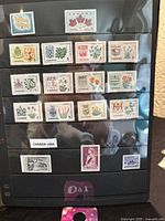 Photo showing multiple Canada stamps from mid-1960s featuring provincial flowers and coats of arms in a protective sleeve.