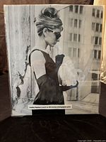 Front view of the full unframed black and white photo print mounted on board showing Audrey Hepburn on a city street.