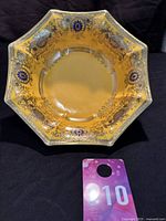 Front view of the octagonal Noritake bowl highlighting orange base color and ornate gold and blue decoration.