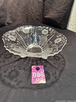 Clear large glass bowl with cornflower etched floral design on black backdrop, showing entire bowl and its form.