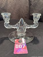 Full front view of the double arm clear glass Art Deco candle holder with floral engraving on the base.