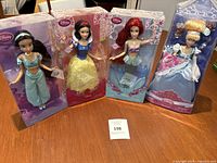 Four Disney princess dolls in original unopened boxes: Jasmine, Snow White, Ariel, Cinderella