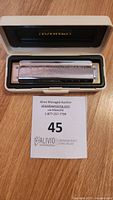 Hohner Marine Band harmonica inside cream-colored protective plastic case.
