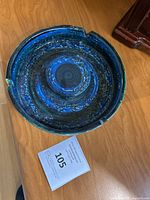 Top view of the large Rimini Blu pottery bowl showing its blue textured glaze and circular interior design with some distressed edges.