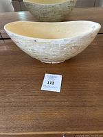 Front and side view showing mother of pearl inlay exterior and plaster/clay interior bowl shape.