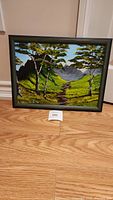 Frontal view of the framed oil painting showing the entire landscape with two birch trees and distant mountains.