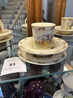 Side view of the three-piece set stacked, showing cup, bowl, and plate with Peter Rabbit bunny designs.