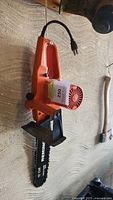 Overall side view of the orange Remington electric chainsaw showing power cord and handle.
