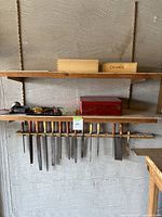 Shelf with chisels and saws hanging, hand planes and files on shelf