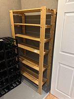 Wood shelving unit with five wooden shelves and vertical supports.