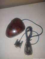 Top view of the wired computer mouse designed with a burl wood grain pattern and glossy finish, showing asymmetrical ergonomic shape and cable.