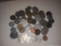 Photo showing a mixed assortment of coins varying in size, color and condition laid out on a flat surface.