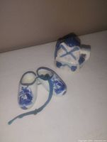Photo of three Dutch-themed ceramic miniatures: a windmill, clogs, and a shoe on white surface for lot identification.