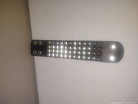 Black wide folding leather bracelet with two rows of silver pyramid studs and a center row of darker studs, secured with four metal snap buttons.